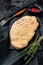 Raw Wiener Schnitzel, breaded steak ready to cook. Black background. Top view