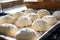 Raw yeast dough balls in tray before baking. Concept home baking bread. Generative AI