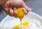 The raw yellow egg yolk is rubbed in the hand and runs down the finger. Manual pressing of a fresh chicken egg. A woman crushes an