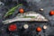 Raw zander, walleye fish with herbs. Black background. Top view