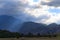 Ray of sun through thunderclouds. Summer mountain landscape. Thunderstorm and rain