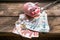 A ray of sunlight on the funny piggy bank and bunch of banknotes and coins on the aged rough wooden windowsill.