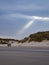 A ray of sunlight pointing towards a group of people at the beach