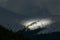 A ray of sunshine that illuminates just a spot on the mountain peak - snow mountain landscape