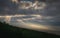 Rays of light through the clouds in Panoramic view of Ngorongoro Conservation Area at sunrise from the mountainside. Tanzania,