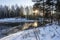 The rays of the low winter sun on the mirror ice of a small backwater