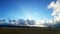 Rays of the sun shine over dark clouds on the blue sky background over river