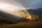 Rays of Sunlight in a Valley with a Beautiful Rainbow