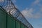 Razor wire on top of green fence guarding French ferry terminal.