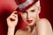 Razzle Dazzle. Portrait of a beautiful showgirl with red lipstick and a sparkly red hat against a red background.