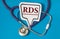 RDS - acronym on white figure sheet on a blue background with a stethoscope