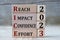 REACH IMPACT CONFIDENCE EFFORT 2023 - words on wooden blocks on gray background