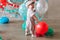 Reaching for balloons Baby boy sitting on floor reaching for balloons on his first birthday