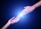 Reaching and touching hands. Bright light star flare with touching fingertips.