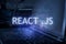React .js inscription against laptop and code background. Learn react programming language, computer courses, training