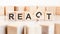 react - words from wooden blocks with letters, of inform brief concept, white background