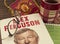 Reading autobiography book by Alex Ferguson, a football coach. Glasses, sports pennant