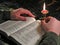Reading Bible by candlelight