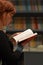 Reading book close up view of a woman red hair profile hand holding an open book