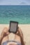 Reading from e-reader relaxing on the beach