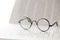 Reading glasses close-up on the pages of a book on a light blurred background.Education and schooling. Symbol of study