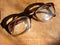 Reading glasses and old book, glasses on aged shabby background