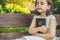 Reading the Holy Bible in outdoors. Christian girl holds bible in her hands sitting on a bench