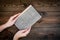 Reading and self-development. Hands hold old book on dark wooden background top view copy space