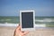 Reading during vacation, nice leisure, female hand hold square e-book reader tablet in white frame with dark grey screen