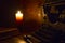 Reading and writing scenes in ancient times: an old book and an old typewriter on a ruined wooden table lit by a candle on a woode