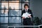 Reads documents. Portrait of handsome young businessman in black suit and tie