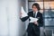 Reads documents. Portrait of handsome young businessman in black suit and tie