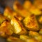 Ready baked potato slices with spices lie in rows after oven close up