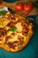 Ready Italian lasagna, on a green wooden background with basil, tomatoes. Culinary background, book of Italian recipes, delicious