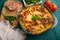 Ready Italian lasagna, on a green wooden background with basil, tomatoes. Culinary background, Italian recipe book, delicious food