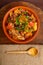 ready-made cholent dish, sprinkled with green onions, in a clay plate on the table