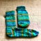 ready-made knitted sock from green striped yarn  handicrafts as a hobby  knitting concept