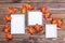 Ready mock up three empty photo frame on a brown wooden background surrounded by orange maple leaves