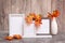 Ready Mock up. Three empty photo frames on a stand and a vase with orange maple leaves stand on the table