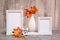 Ready Mock up. Two empty photo frames on a stand, a vase with orange maple leaves and a white alarm clock stand on the table.