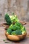 Ready to eat fresh raw broccoli is divided into inflorescences in a wooden plate on a wooden table. Healthy lifestyle, nutrition