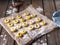 Ready-to-freeze potato nyokki, laid out on parchment on a plank table, in the foreground a denim cloth, in the background a bag of