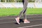 Ready to go. Close up photo of shoe of female athlete on the starting line. Girl on Stadium track, preparing for a run. Sports and