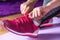 Ready to Move: Young Female Legs with Red Sneakers on Purple Fitness Mat
