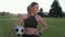 Ready to play. Portrait of attractive sporty woman holding soccer ball in hand, looking at camera and smiling while