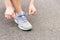 Ready to start. closeup woman hands lacing her purple shoes over asphalt track