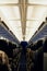 Ready to take to the sky. Rearview shot of unidentifiable passengers seated in an airplane cabin.