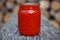 Ready tomato paste in a jar on the table. Tomato ketchup sauce in a glass bowl.