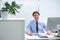 Always ready and willing to help his colleagues. a young businessman sitting at his desk.