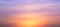 Real amazing panoramic sunrise or sunset sky with gentle colorful clouds. Long panorama, crop it. Evening sky scene with golden